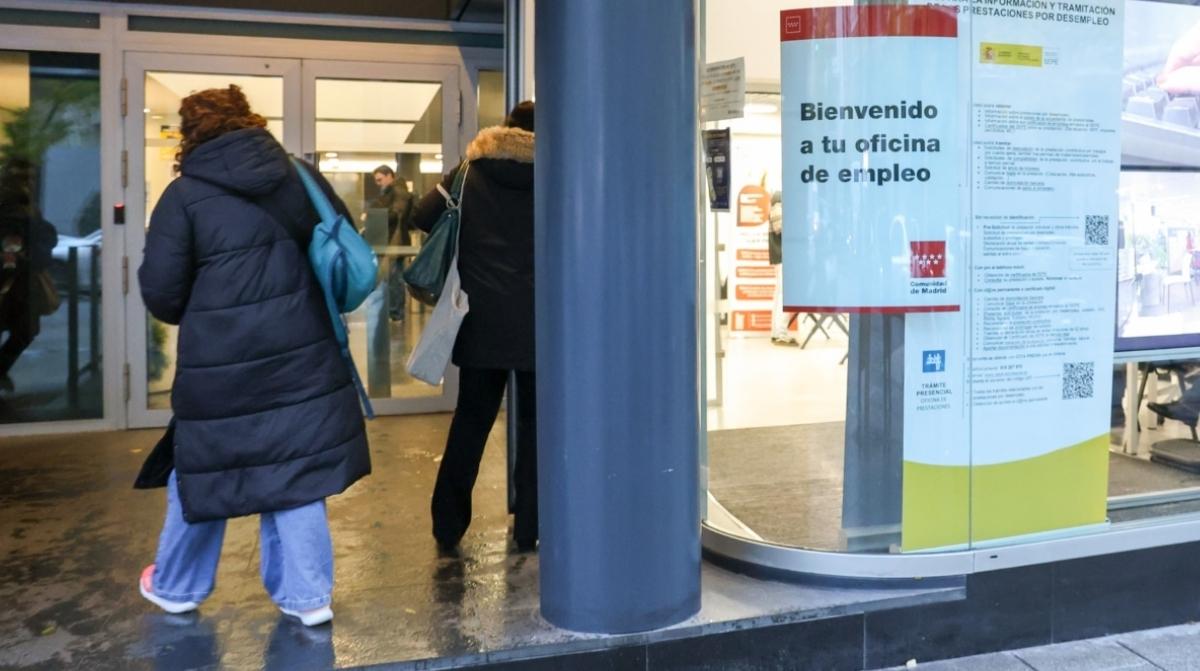 Personas entrando en una oficina de empleo de la Seguridad Social para gestionar cotizaciones sin trabajar
