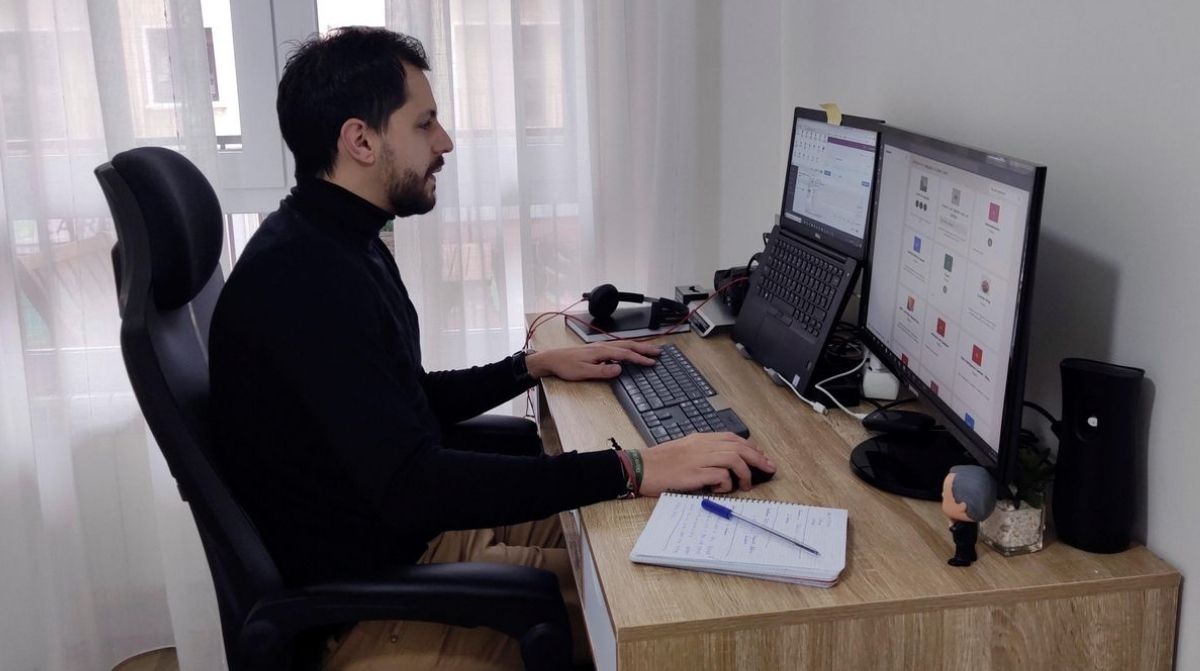 Trabajador en casa realizando teletrabajo con ordenador para acceder a ayuda de 2500 euros