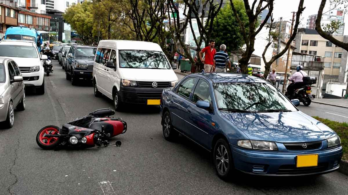 Accidente laboral de tráfico durante el desplazamiento al trabajo con una moto caída y retenciones en carretera