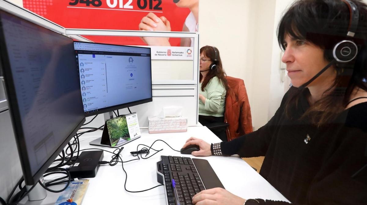 Trabajadora de atención al cliente atendiendo llamadas telefónicas en una oficina tras la nueva ley que limita las esperas a tres minutos