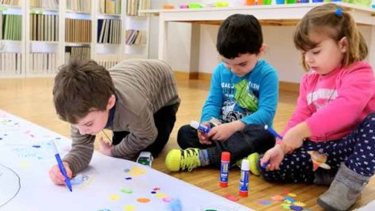 Niños pintando y realizando manualidades en una guardería de Santander.