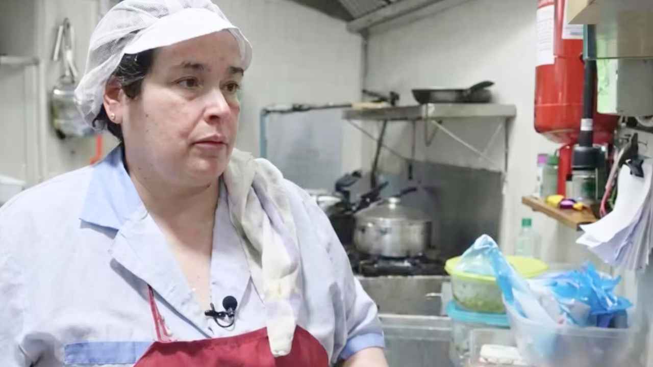 María prepara varios menús del día en la cocina de su restaurante
