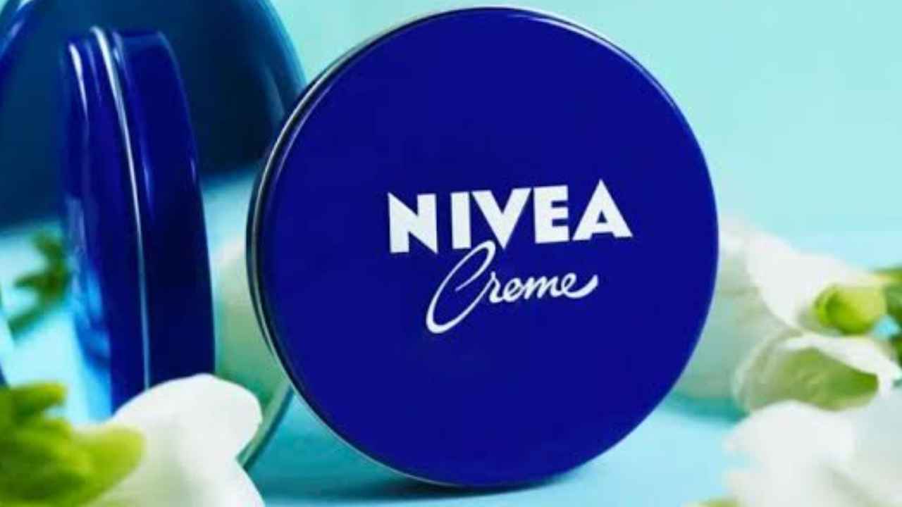Lata azul de crema Nivea junto a un protector solar para explicar que hidratar no equivale a proteger del sol.