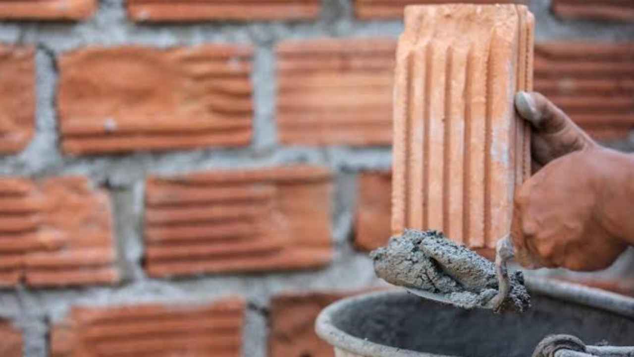 Albañil veterano colocando ladrillos en una obra de construcción.