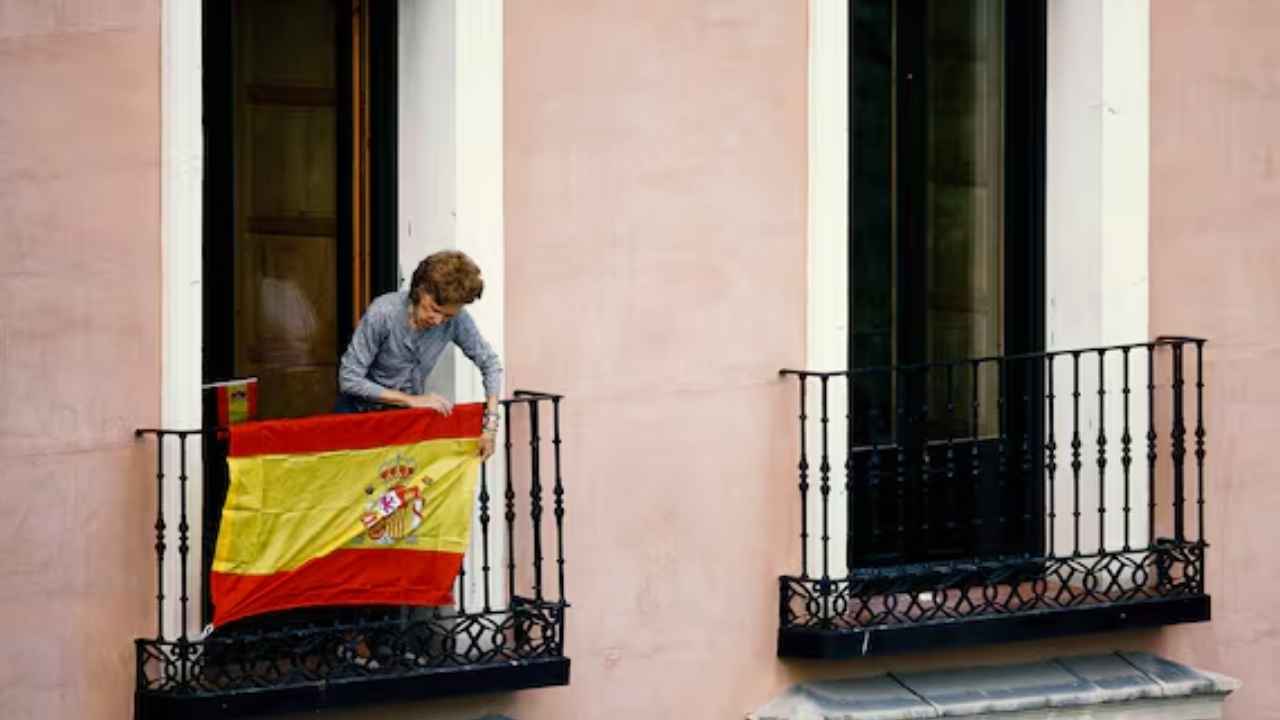 Bandera de España colgada en el balcón de un edificio residencial