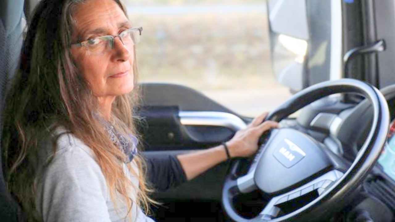 Conductora profesional dentro de la cabina de un camión antes de iniciar una ruta
