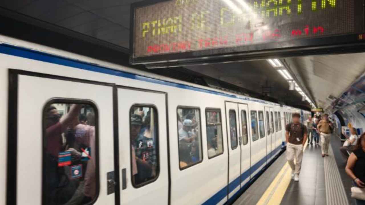 Viajeros junto a un tren de Metro de Madrid durante una jornada de altas temperaturas