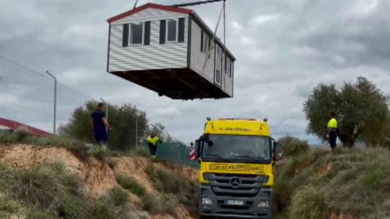 Casa prefabricada elevada por una grúa durante su instalación en una parcelaUna grúa traslada una casa prefabricada durante los trabajos de instalación en una parcela.