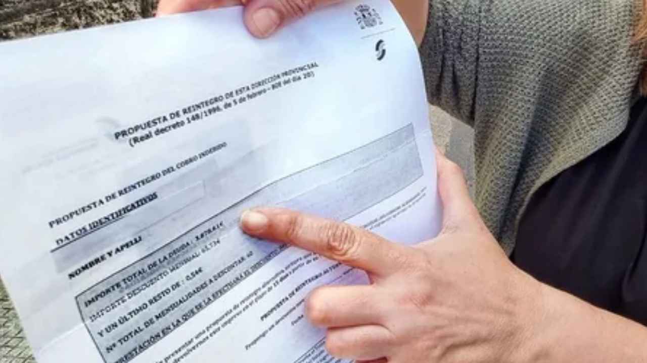 Mujer muestra una resolución relacionada con la devolución del Ingreso Mínimo Vital