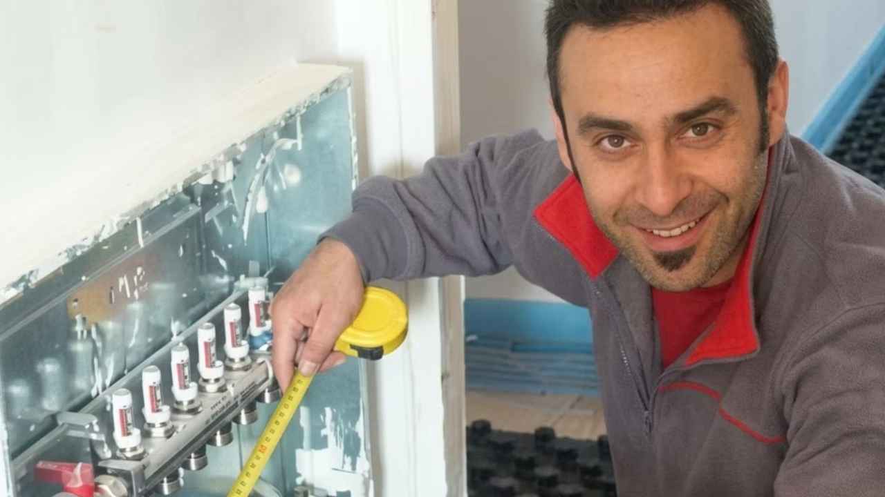 Fontanero veterano explica una instalación a un alumno en prácticas que sostiene un teléfono móvil.