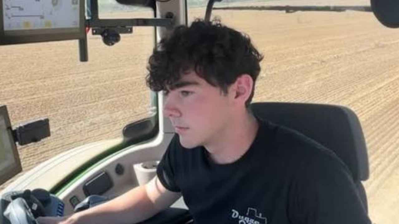 Javier Duque trabajando junto a un tractor en una explotación agrícola de Fraella, Huesca.
