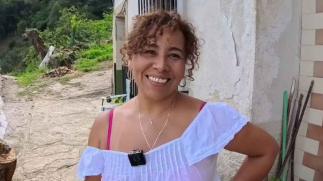 Mónica junto a dos cabras frente a una casa tradicional en una aldea de Asturias.