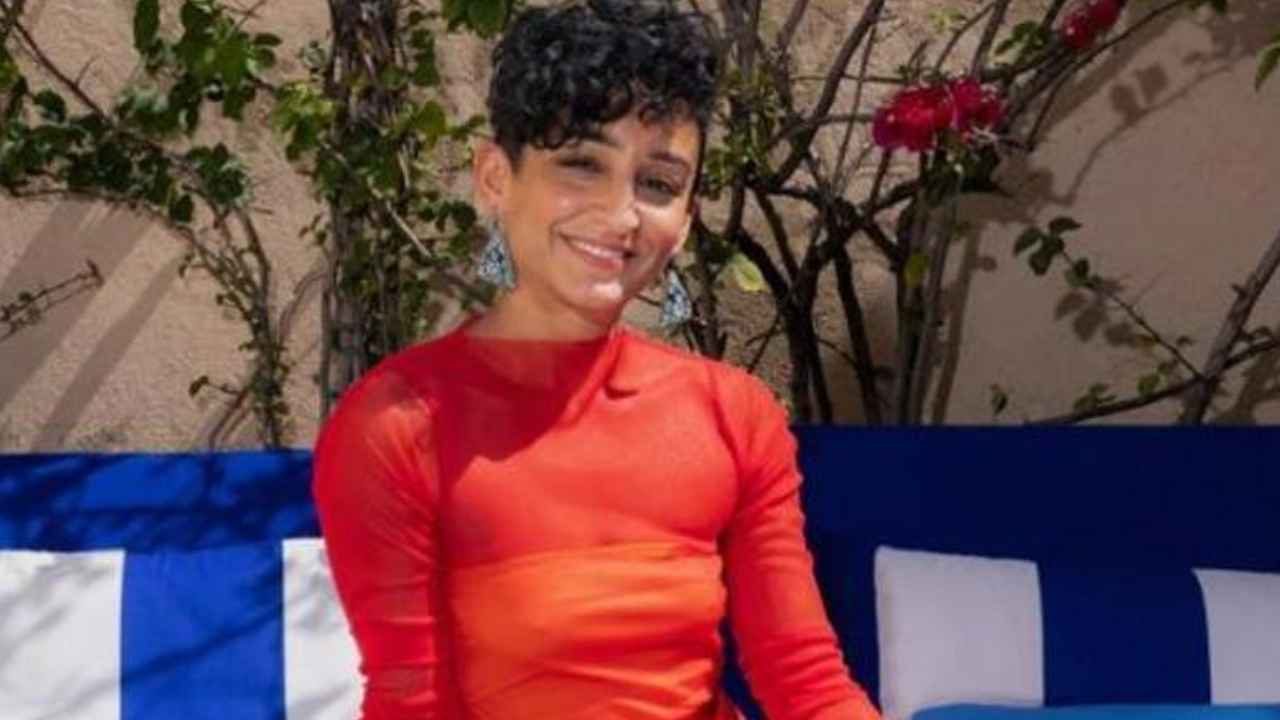 Mujer sentada ante un ordenador con una hoja de cálculo abierta en una oficina.