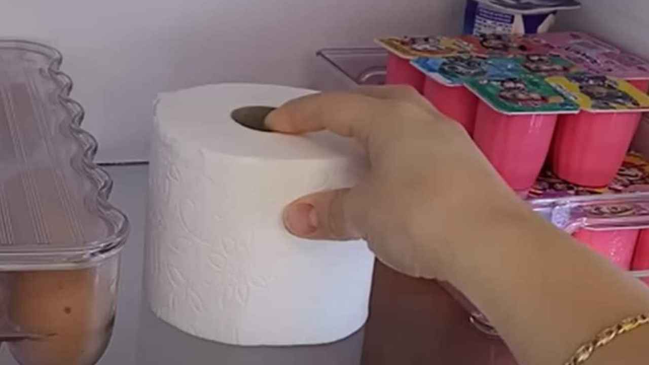 Rollo de papel higiénico colocado en una balda del interior de un frigorífico.