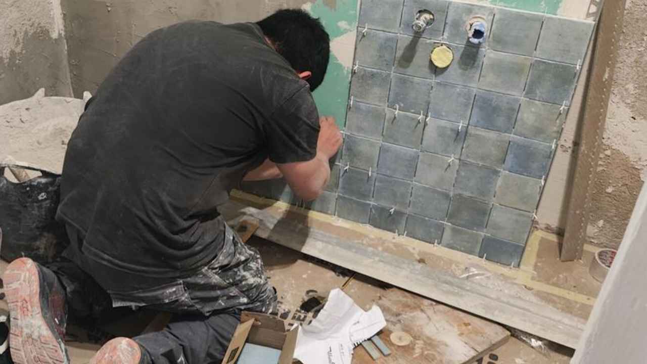 Trabajador reformando un baño en una vivienda