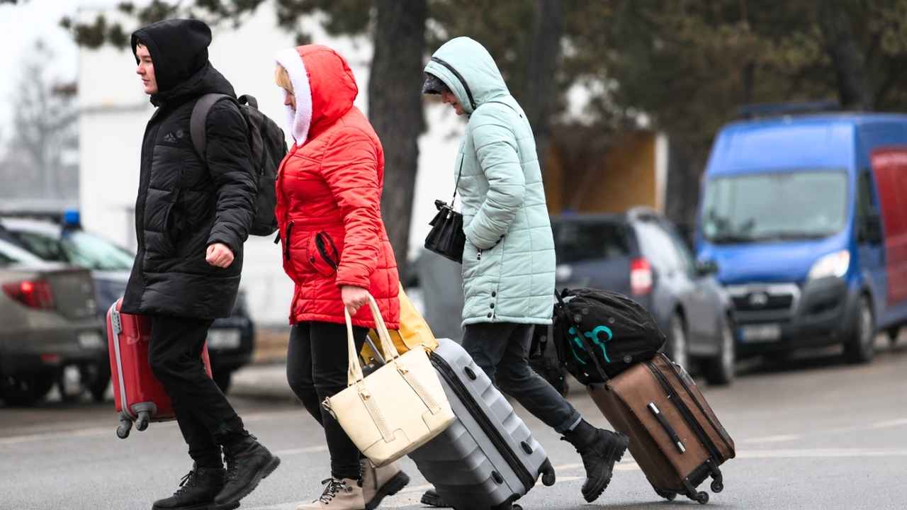 Viajeros con maletas en una estación española como imagen de recurso sobre movimientos migratorios.