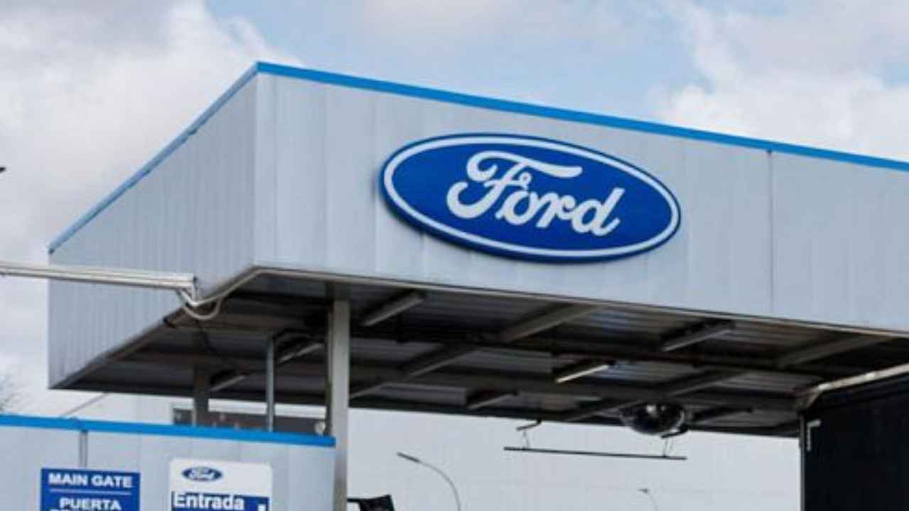 Entrada de una fábrica de Ford con el logotipo de la compañía en la fachada
